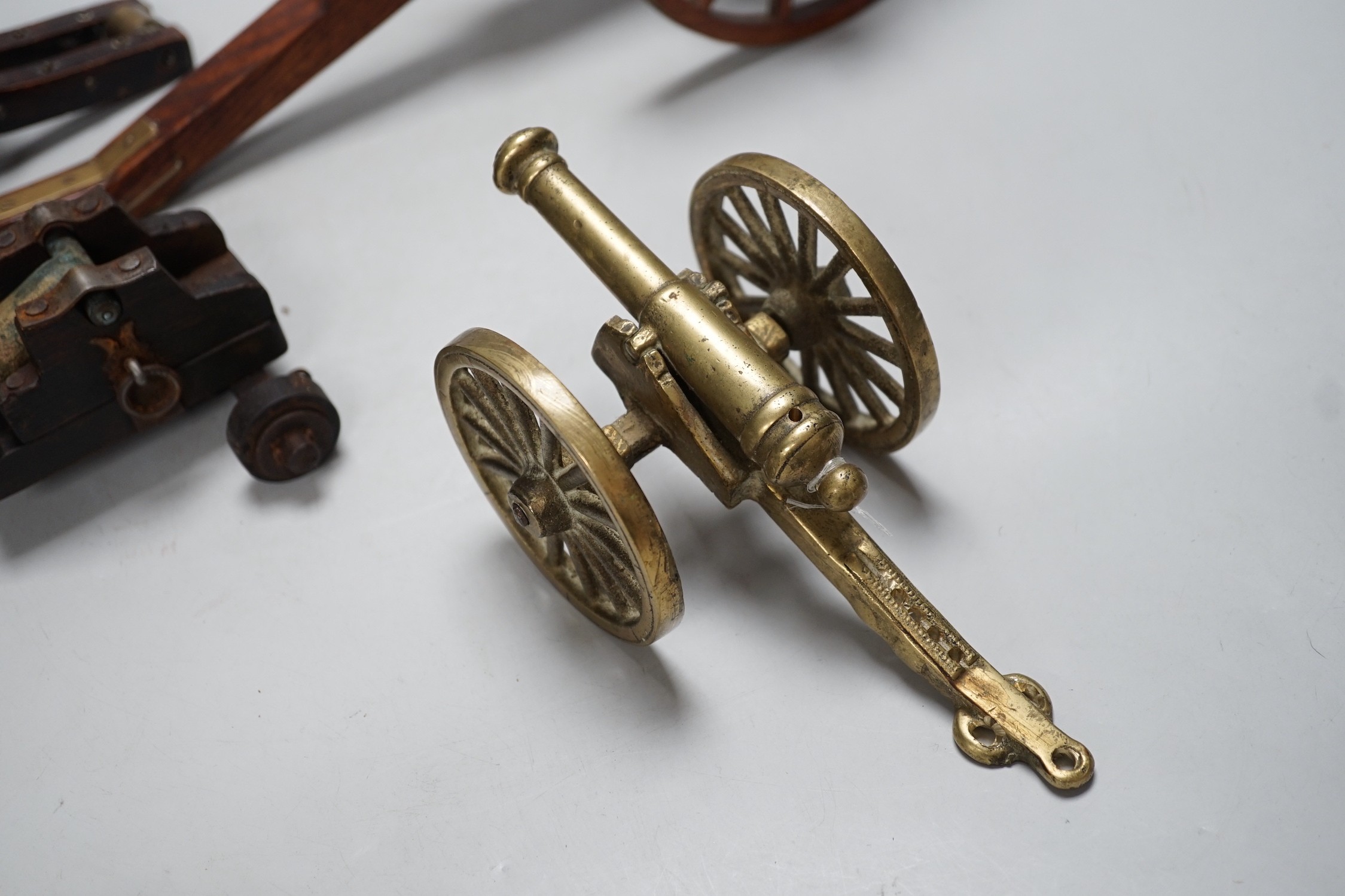 A bronze 'Napoleon bust' desk seal, 8.5cm tall, together with four models of cannons. Largest 39cm wide